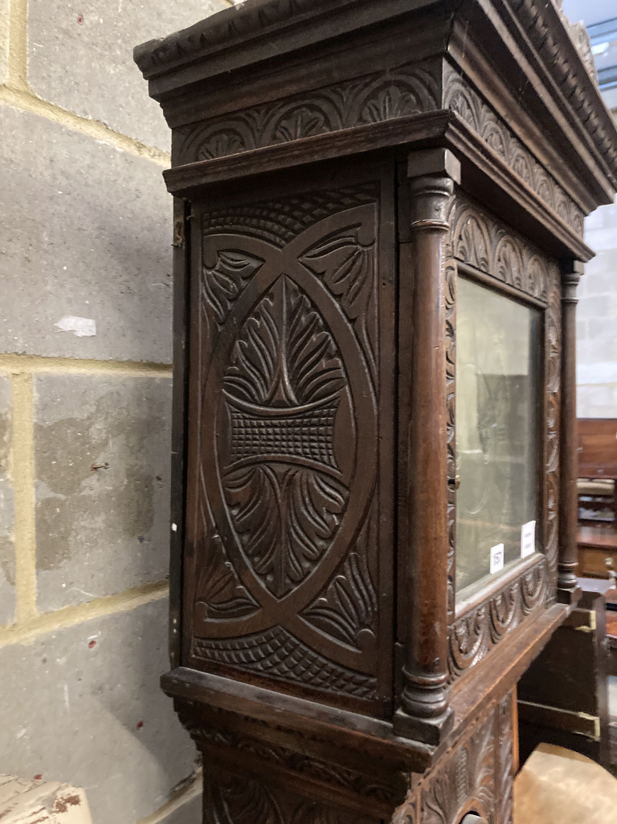 Simon Worley of Starton - an early 18th century 8 day longcase clock, contained in a later carved oak vase, height 210cm